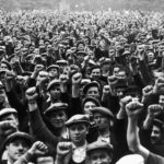 13 June 1936: Striking building workers raise their fists in salute during a rally in the Bois de Vincennes, Paris. (Photograph by Keystone/Hulton Archive/Getty Images)