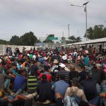 20 October 2018: Participants in the migrant caravan sit on a bridge over the Suchiate River which forms the Guatemala-Mexico border in Ciudad Tecun Uman, Guatemala. (Photograph by John Moore/Getty Images)