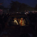 8 May 2014: BJP leader Narendra Modi flashes the v-sign while being driven through the streets of Varanasi, India. (Photograph by Kevin Frayer/Getty Images)