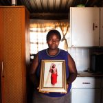 21 December 2017: Nombuyiselo Ntlane at her home in Snake Park where she holds a photograph of her son, Siphiwe. He was shot dead by a migrant spaza-shop owner when he was 14. (Photograph by Oupa Nkosi)