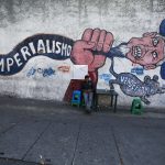 9 March 2015: A man sits in front of graffiti, which reads "imperialism" in Caracas, after the United States ordered sanctions against seven officials from the oil-rich country. (Photograph by Jorge Silva/Reuters)