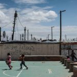 24 September 2018: Children play in front of recently- scrawled gang tags in Blikkiesdorp.