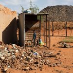 11 October 2016. Two boys play in the remains of a house in Arbor. A coal mine has sprung up and begun encroaching on the settlement.