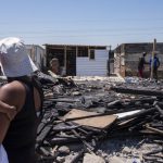 25 October 2018: A woman and child gaze at the destruction caused by the fire that destroyed hundreds of homes in Khayelitsha.