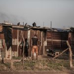 8 October 2018: A resident is pictured outside one of the many homes built in Happiness Village, just across from Marievale. Residents say they are regularly intimidated by soldiers who want them to leave.