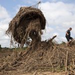 31 March 2019: Stephen Fonseca searches a pile of debris in a flooded village near Dombe.