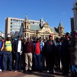 Undated: Nelson Mandela Bay union coordinator Siphiwo Ndunyana (maroon jersey), provincial chairperson Mlamli Sidzumo (black cap and jacket) and provincial deputy chair Bongani Cola (red shirt and denim jacket). (Photograph by Anna Majavu)