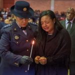 9 July 2019: Shaldene Prins is comforted by a police officer as she prepares to light a candle at the memorial service for her husband, Sergeant Donovan Prins.