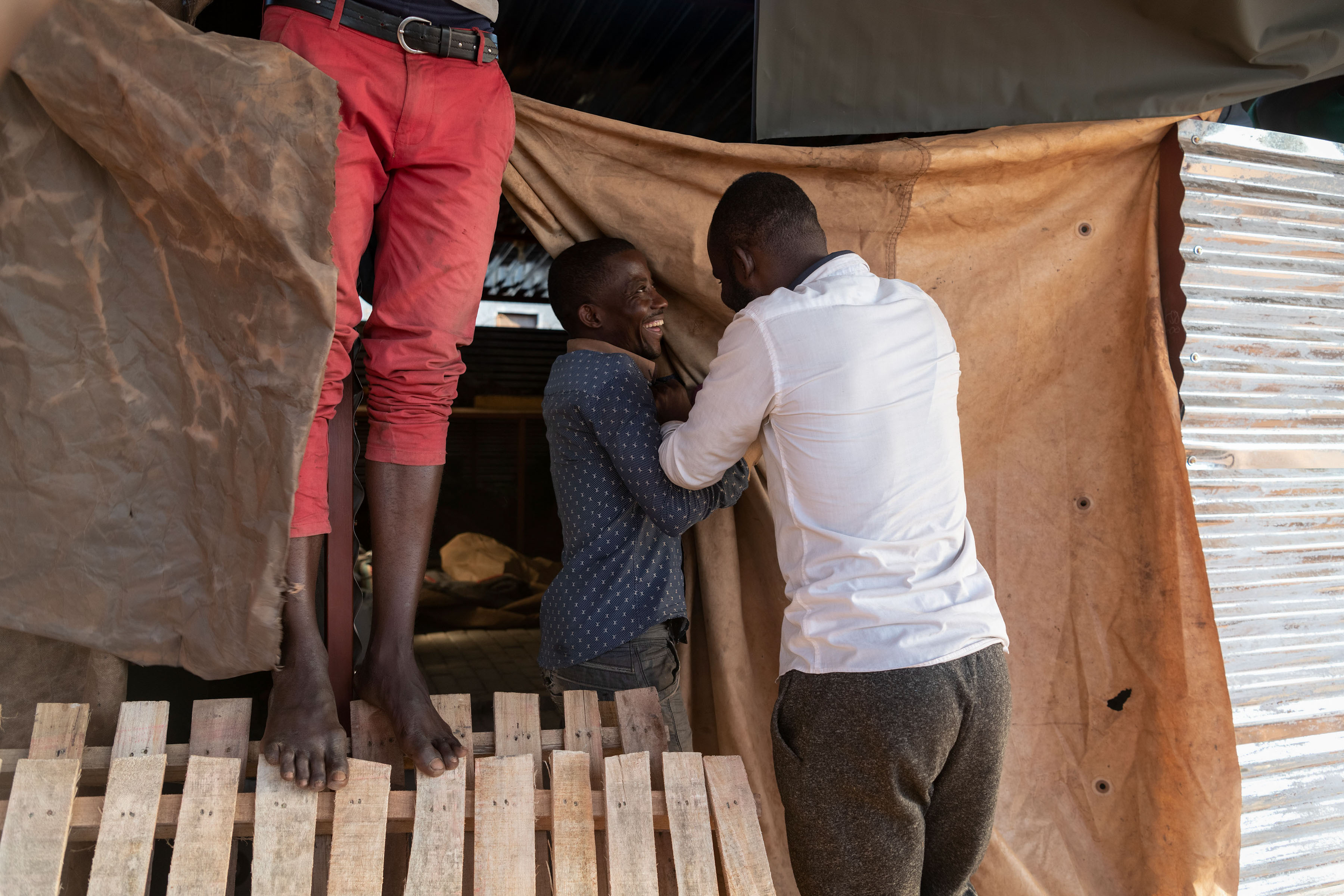 24 July 2019: Asylum seekers from the DRC and Burundi share a joke outside their living quarters at the church grounds.