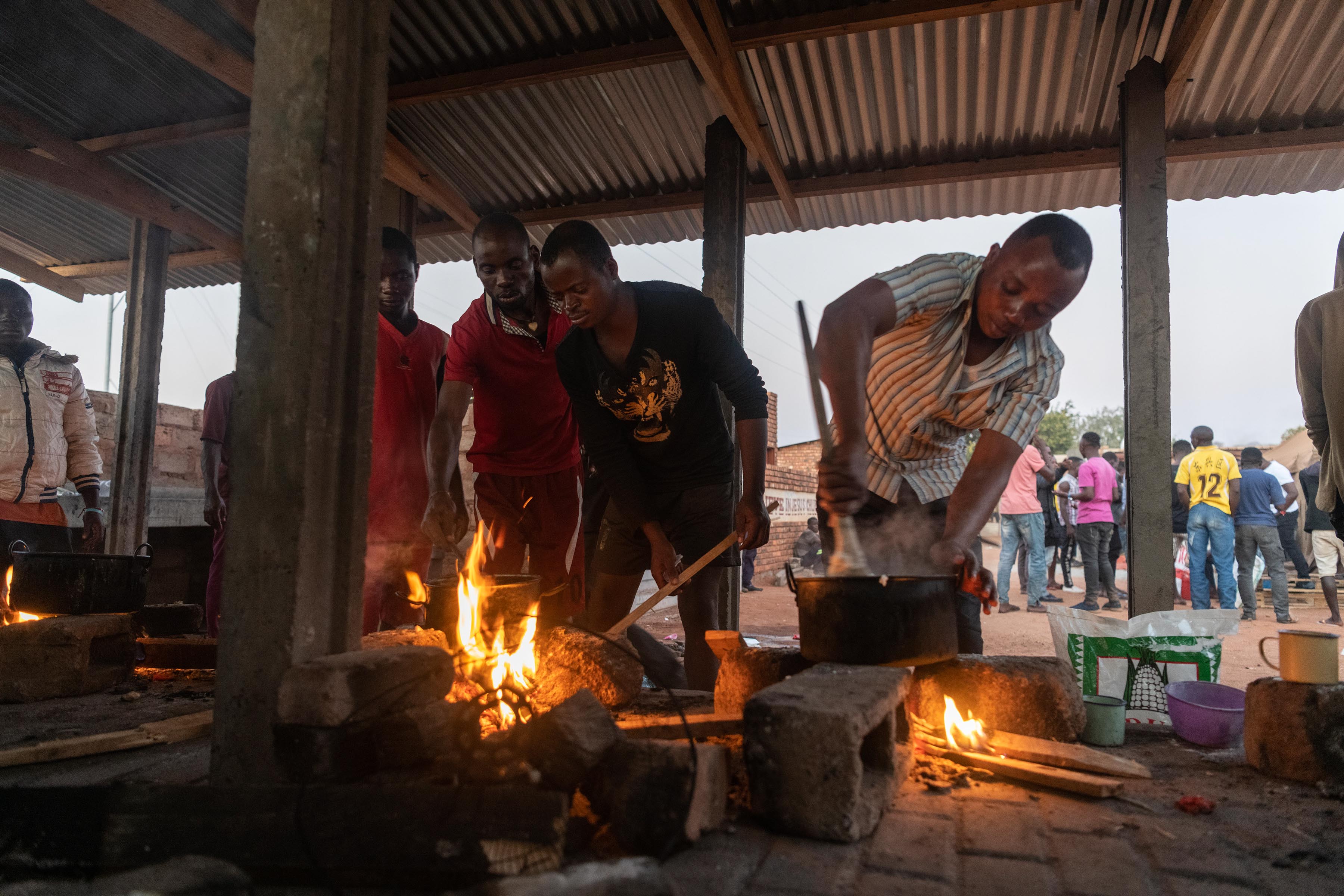 24 July 2019: The men at the shelter, cooking supper over an open fire.