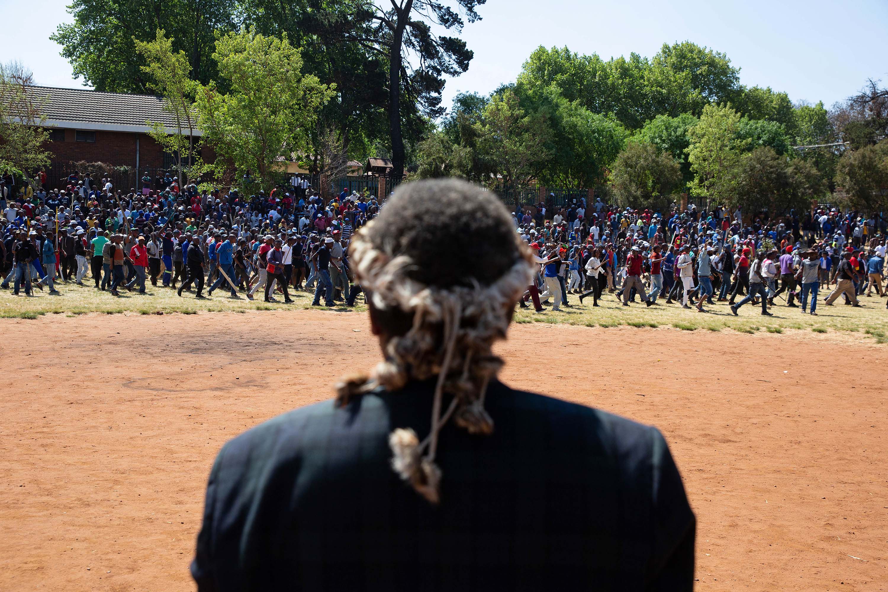 8 September 2019: An induna watches as a dissatisfied crowd of men leaves Murray Park during Mangosuthu Buthelezi’s speech. (Photograph by James Oatway) 