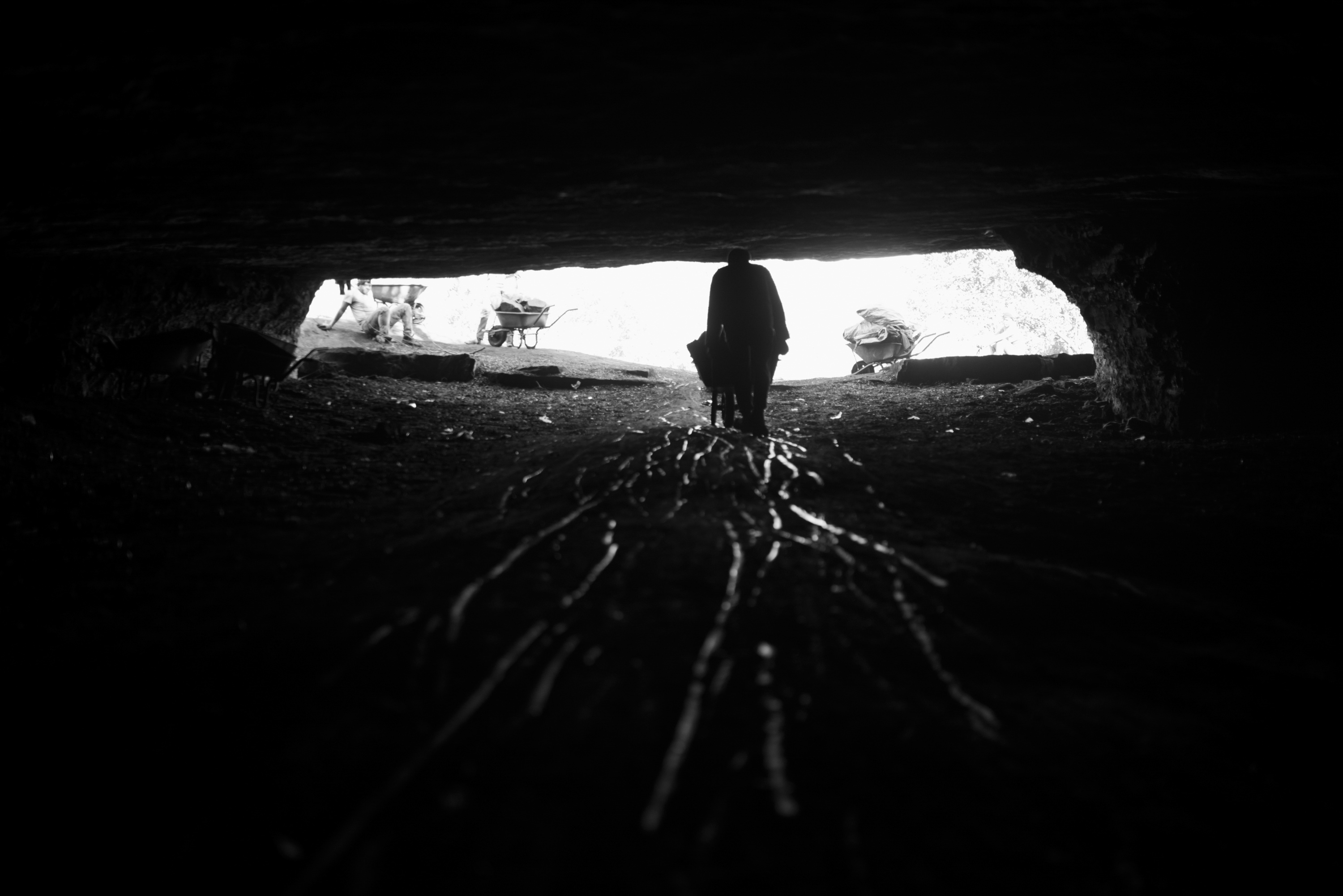 Unlicensed miner exiting the community-made mine shaft. The community mine has rules and a shift schedule, and provides many otherwise unemployed residents with a source of income. Ermelo, Mpumalanga.