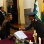 13 November 2019: Interim Bolivian President Jeanine Áñez shakes hands with new commandant in chief of the armed forces General Sergio Orellana Centellas at the presidential palace in La Paz, Bolivia. (Photograph by Javier Mamani/Getty Images)