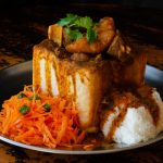 Undated: A quarter mutton bunny chow with sambals, iconic Durban street food that is made by hollowing out white bread and filling it with curry. (Photograph by Jonathan Oberholster/Alamy Stock Photo)