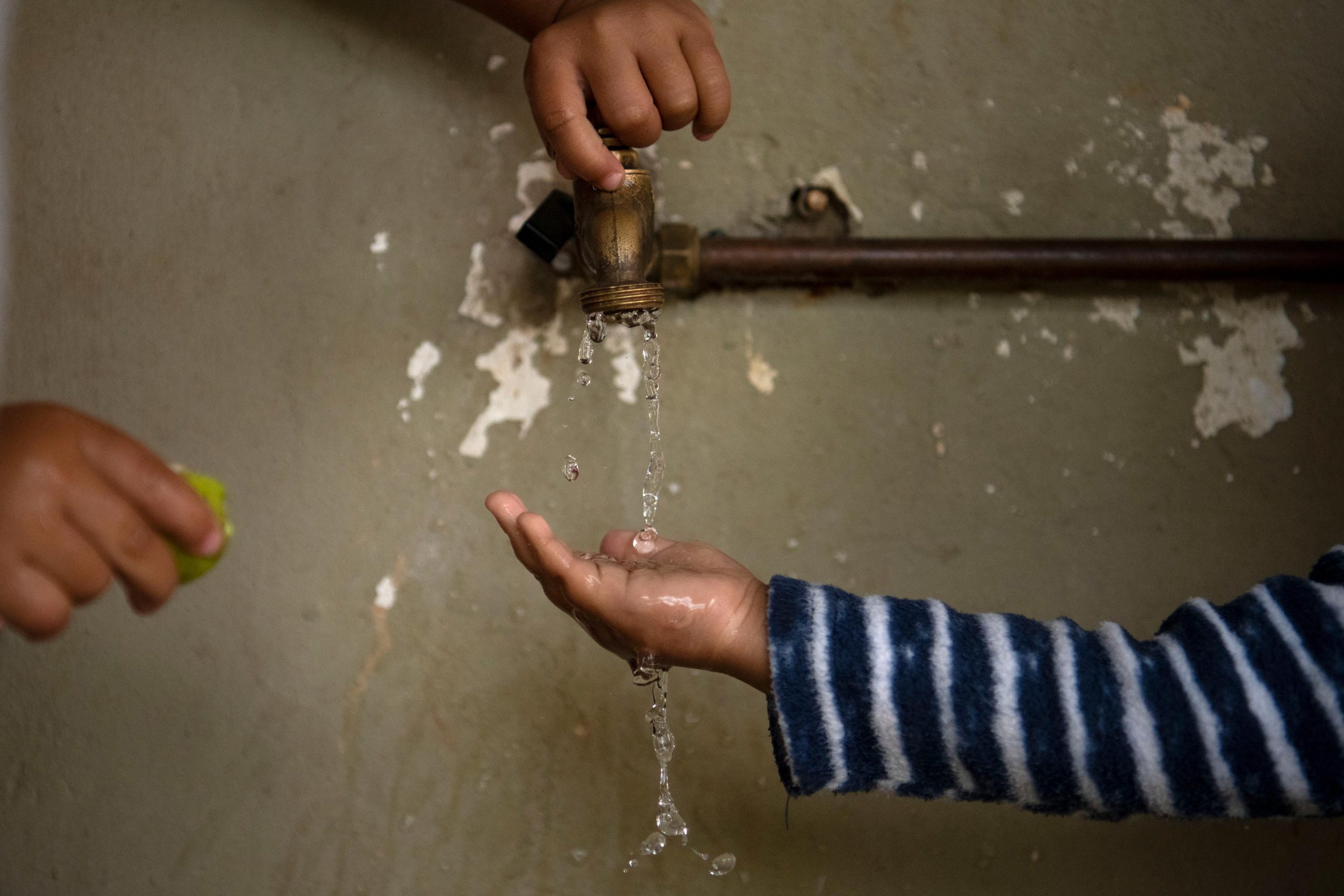 13 December 2019: Children washing their hands before eating pears from the tree in the shelter’s back garden.