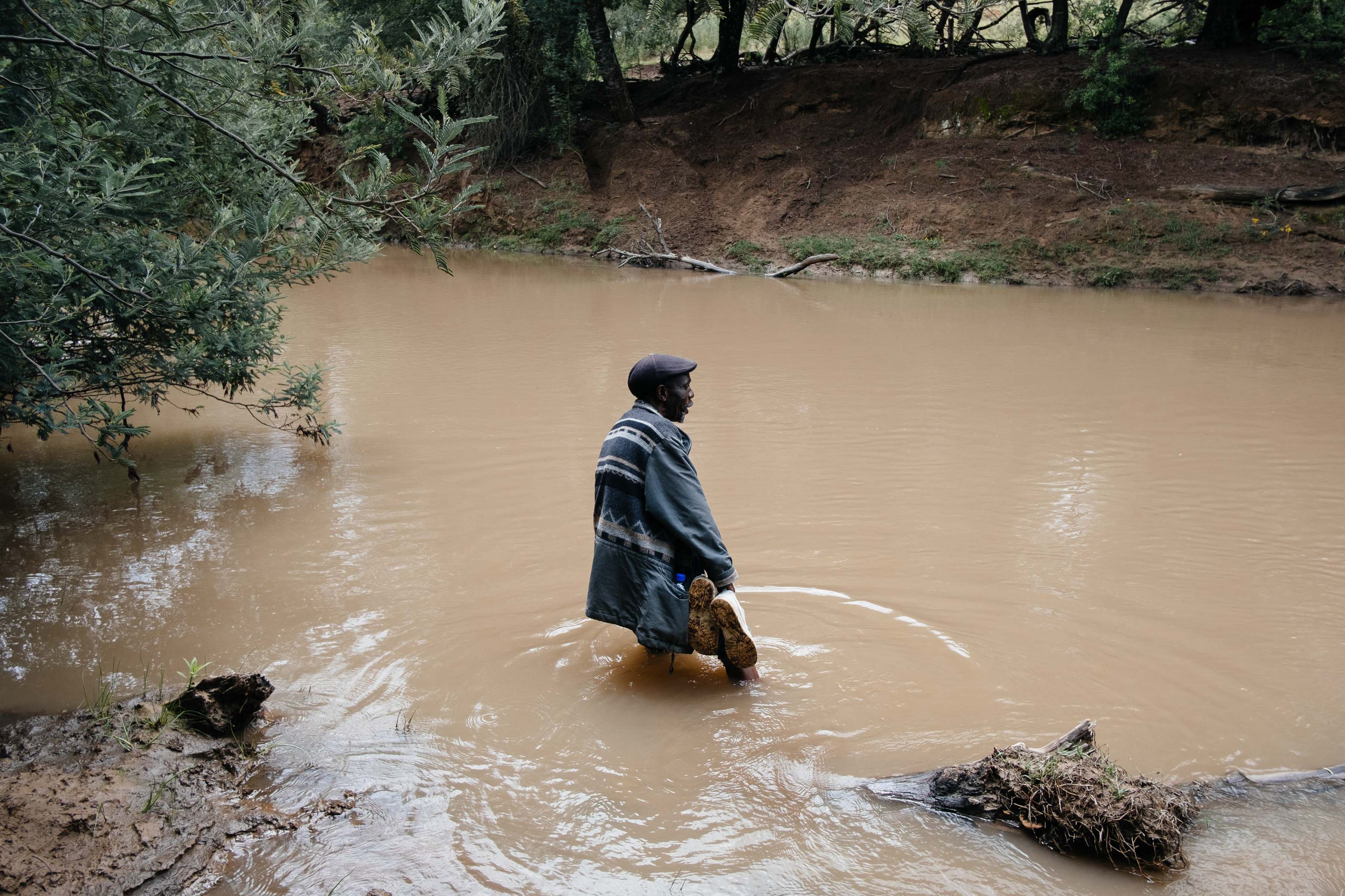 11 December 2019: Elliot Advice Centre paralegal George Nqoko crossing the Ntungela River to get to the Bino’s farm to check on Sibongile Bino, who has cerebral palsy and suffers from epileptic fits. 