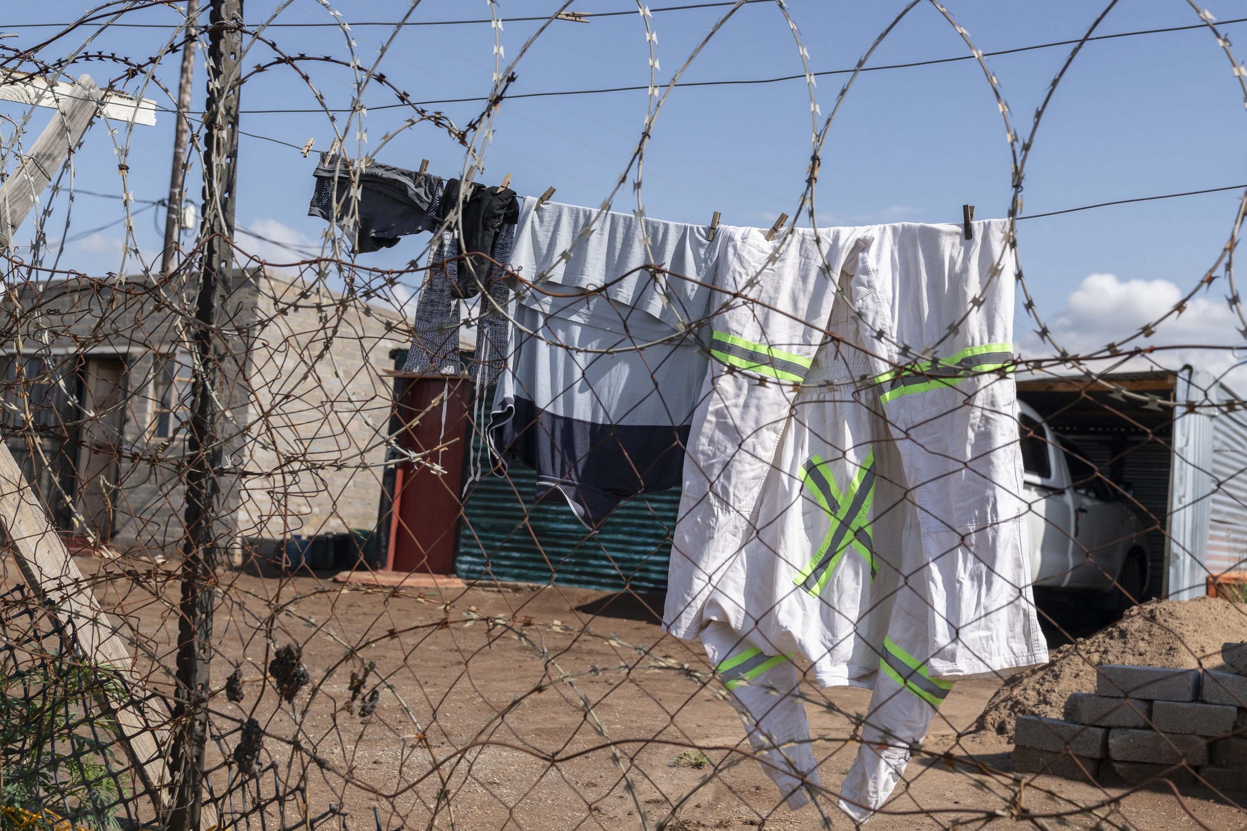 12 February 2020: A miner’s overalls hang from his washing line at the shack settlement of Bokamoso in the North West province. 