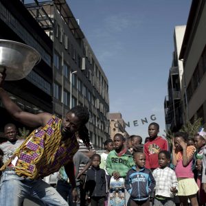 26 May 2012: A street artist performs a dance as children look on in Maboneng, a gentrified district in downtown Johannesburg. (Photograph by Per-Anders Pettersson/Getty)