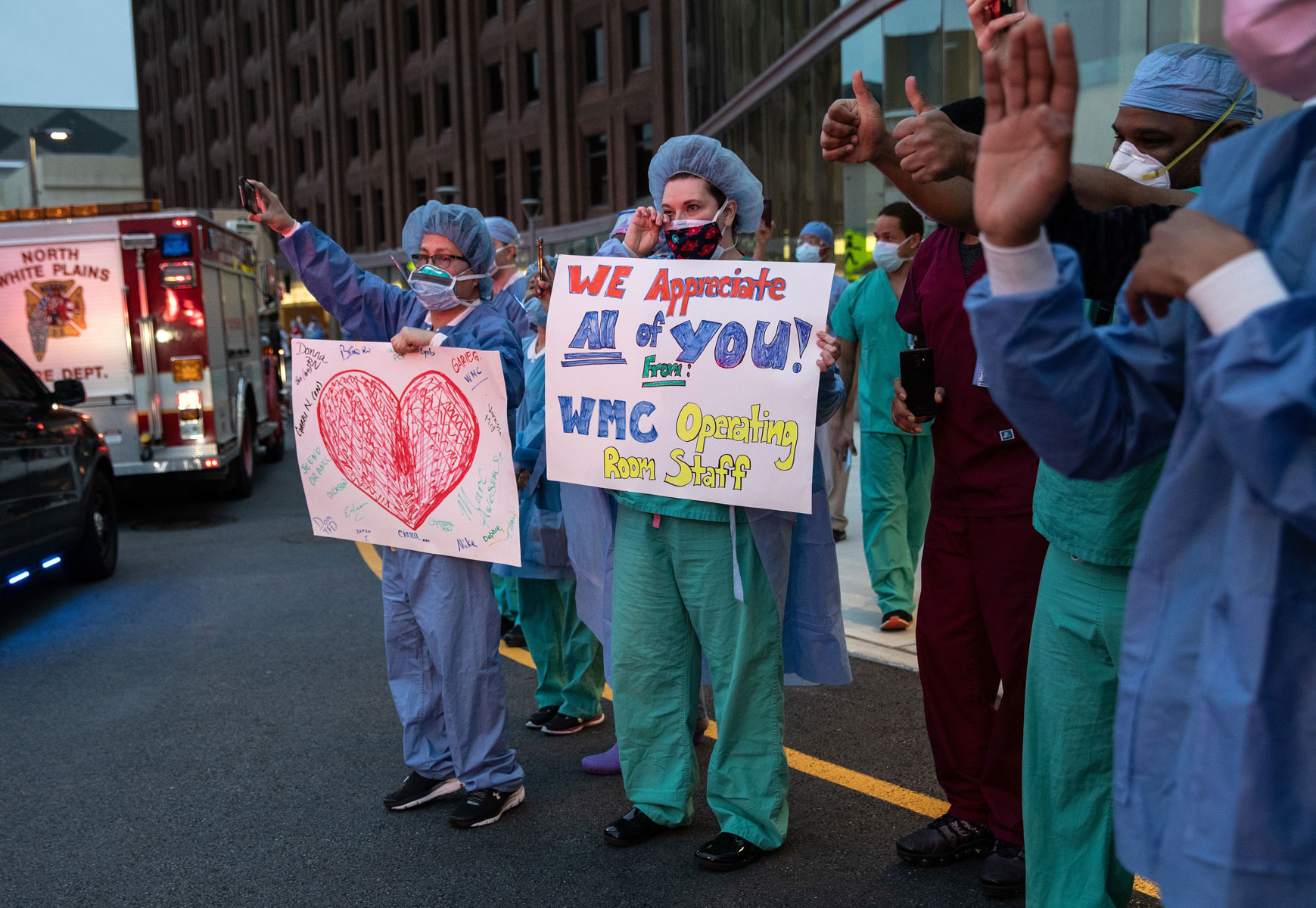 14 April 2020: A nurse wipes away a tear as emergency workers pass by the Westchester Medical Center in Valhalla, New York. They came to thank healthcare workers for their dedication during the Covid-19 pandemic. (Photograph by John Moore/ Getty Images)