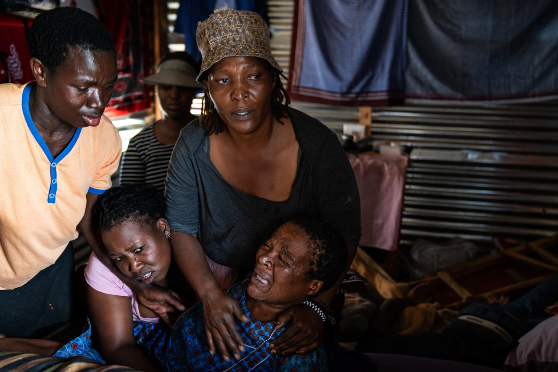 21 April 2020: Lindiwe Ndlovu helps Victoria Maphalale moments before she has a seizure. Police, who stormed the shack and fired rubber bullets, refused to take Maphalale to a clinic to receive medical attention. (Photograph by James Oatway)