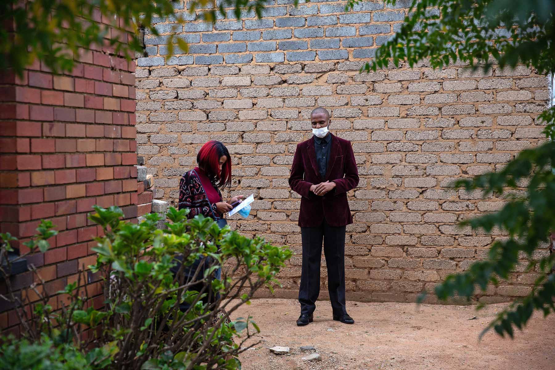 28 March 2020: Angel’s brother Eustin and a friend wait outside their father’s house, where the funeral was held. 