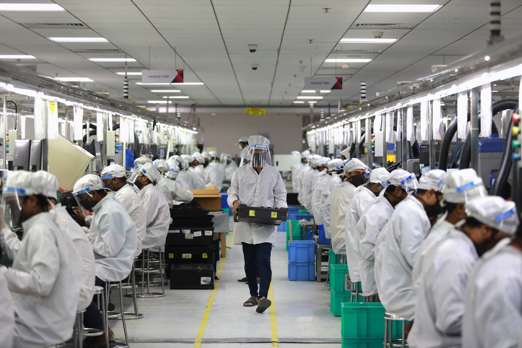 12 May 2020: Workers wearing face shields on a mobile phone assembly line in Noida, India, after some restrictions were lifted during the extended nationwide lockdown. (Photograph by Reuters/ Anushree Fadnavis)