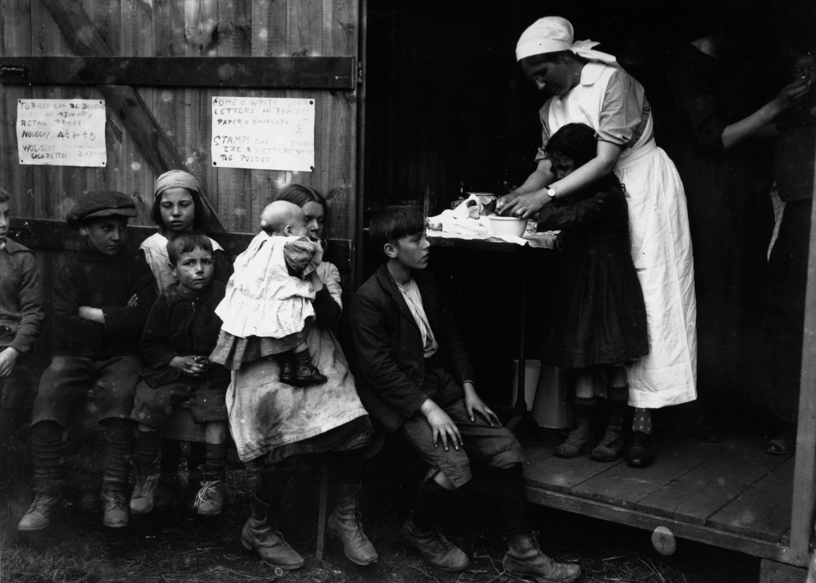 1920: A nurse treats a young boy at a first aid hut for hop pickers at Paddock Wood, Kent.  (Photograph by Central Press/ Getty Images)
