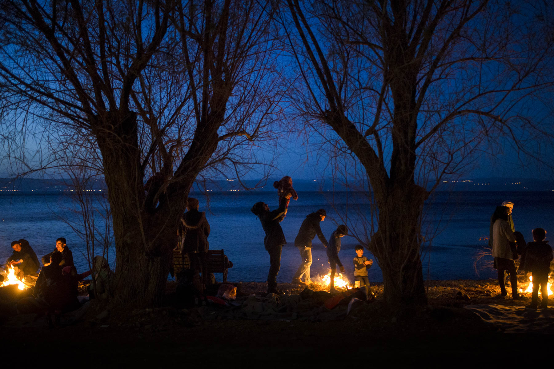 2 March 2020: Migrants gather around fires on the coast of Lesbos island after far-right extremists had set up barricades blocking the way to the Moria refugee camp. (Photograph by Ayhan Mehmet/ Anadolu Agency via Getty Images)