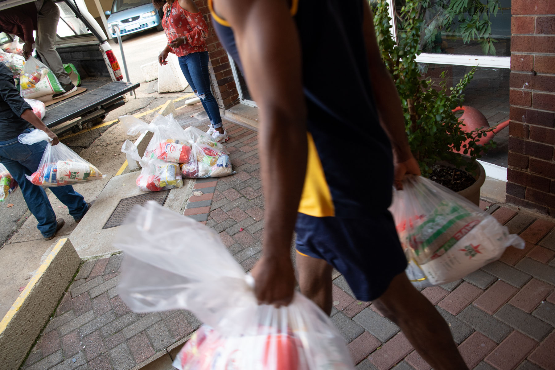 9 May 2020: Jean Bwasa's family help load a bakkie with food parcels to distribute. (Photograph by Daylin Paul)