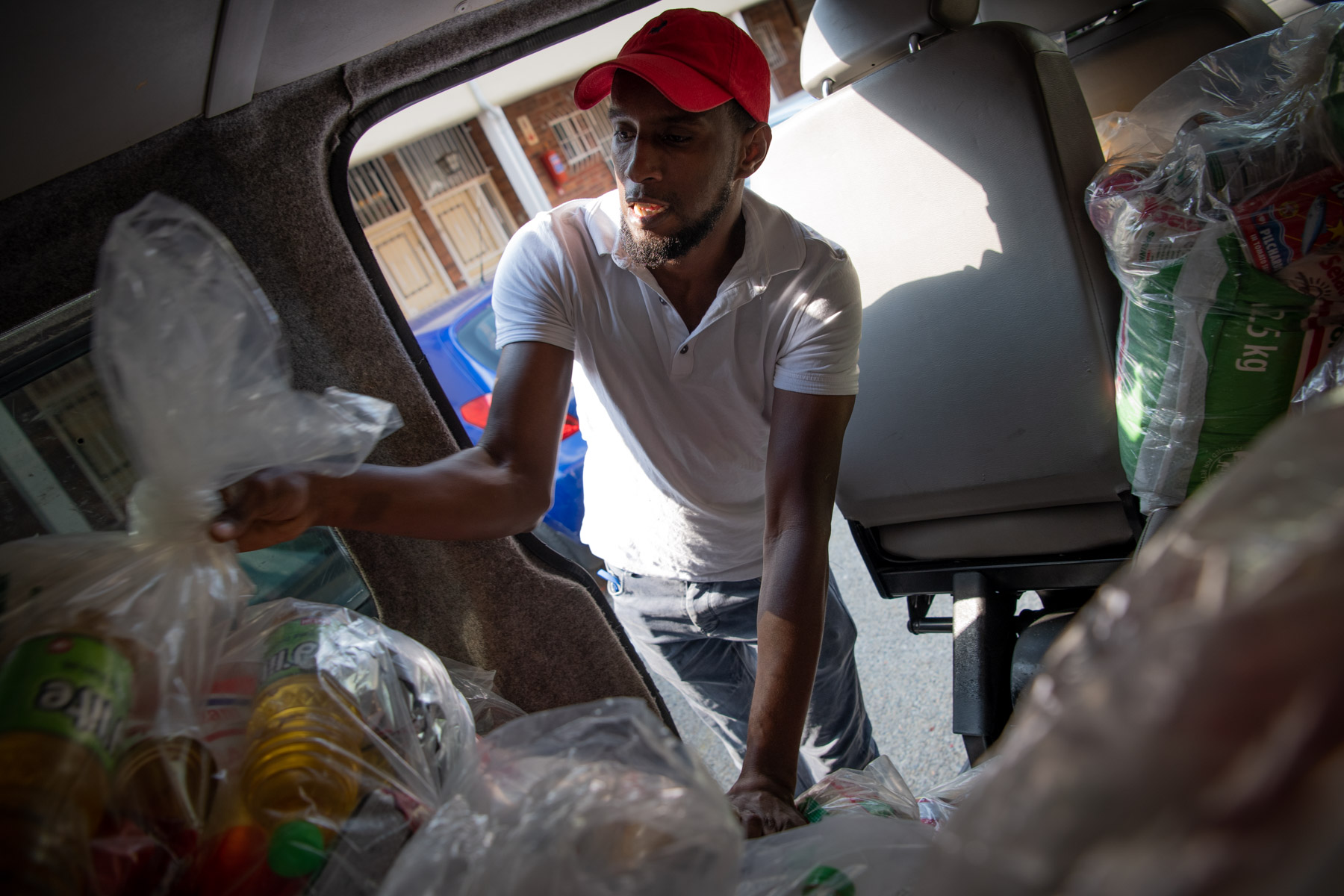 9 May 2020: Ahmed Dhoore, a student at UNISA, disturbed his Ramadan fast to help load food parcels. "I don't have money to donate, but I have my muscles," he said. (Photograph by Daylin Paul)