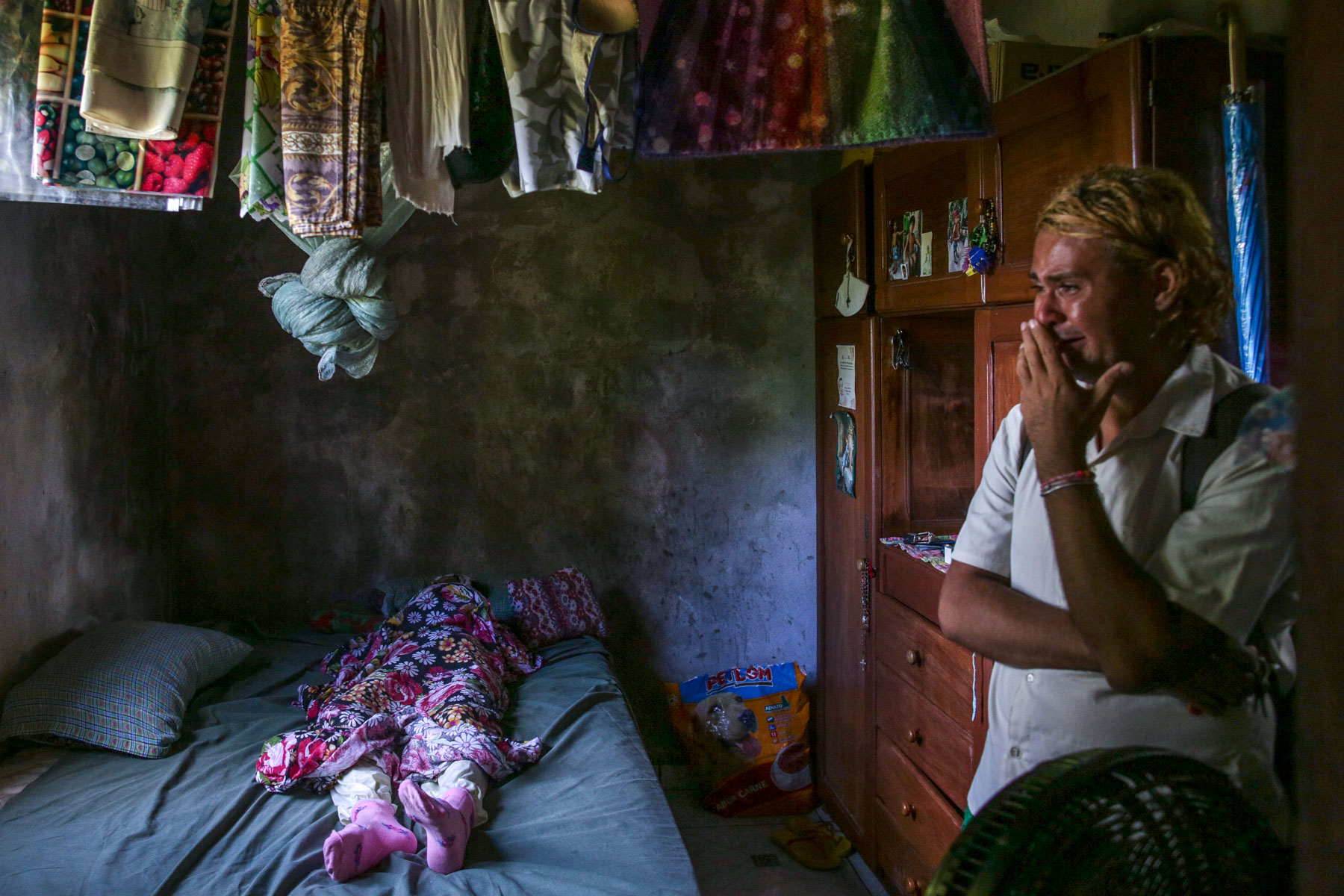 24 May 2020: A man cries as he waits for a team to collect the body of his aunt, Lucia Rodrigues dos Santos, 60, at Zumbi dos Palmares in Manaus, Brazil. (Photograph by Andre Coelho/ Getty Images)