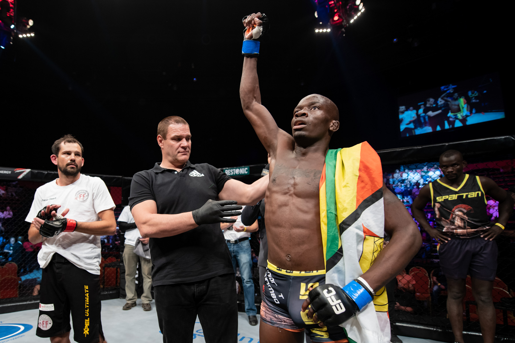 6 October 2018: Far right, Themba Gorimbo looks on as his brother Takunda Gorimbo celebrates defeating Danie Swart in the Fight Night for EFC 74 matchup at Carnival City in Johannesburg. (Photograph by Anton Geyser/ EFC Worldwide/ Gallo Images)