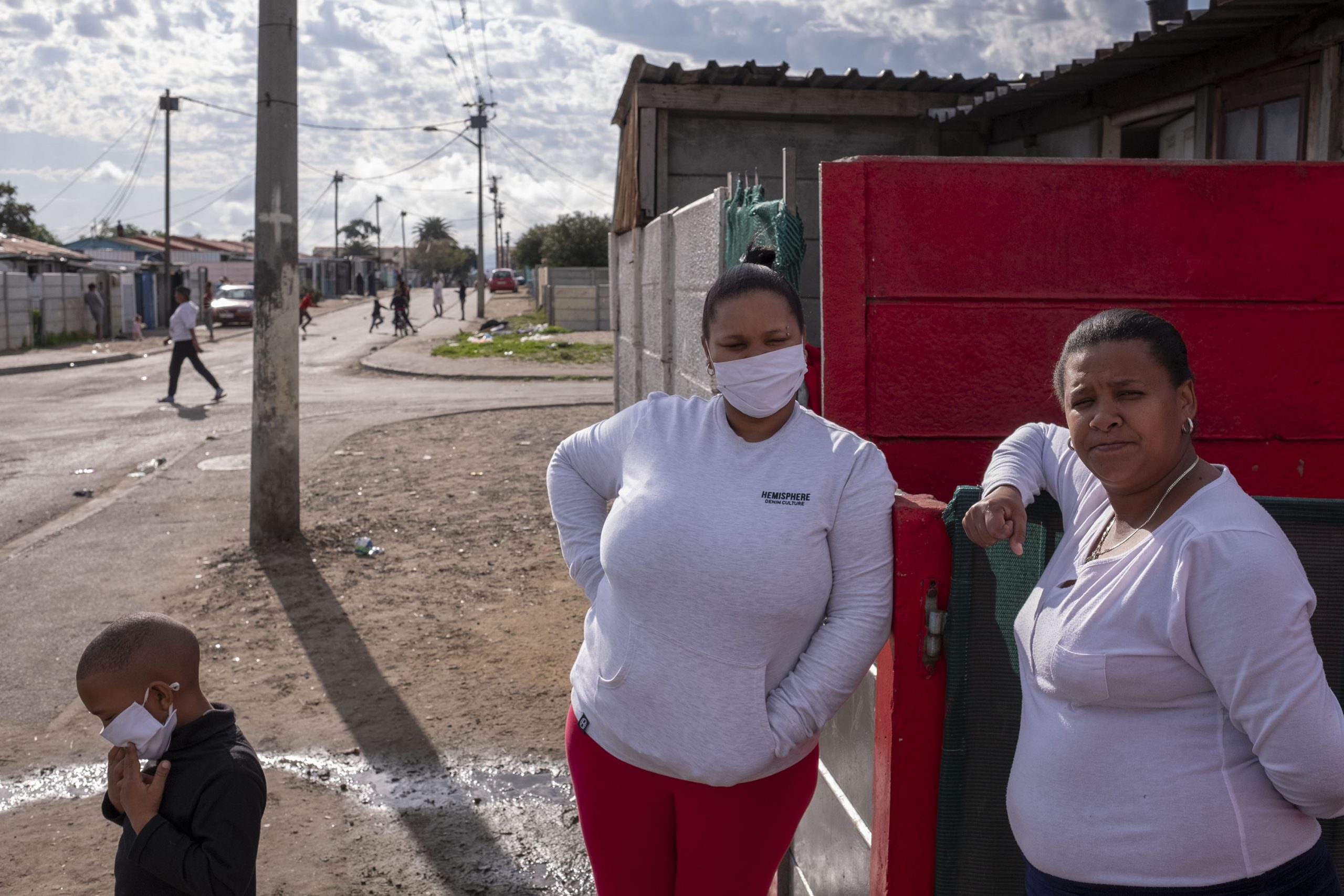 9 June 2020: From left, Angelique Nico, a former colleague of Petrus Miggels, with her son and Nora Southgate, Cecilia Meintjies’ niece, stand outside the couple’s house in Uitsig.