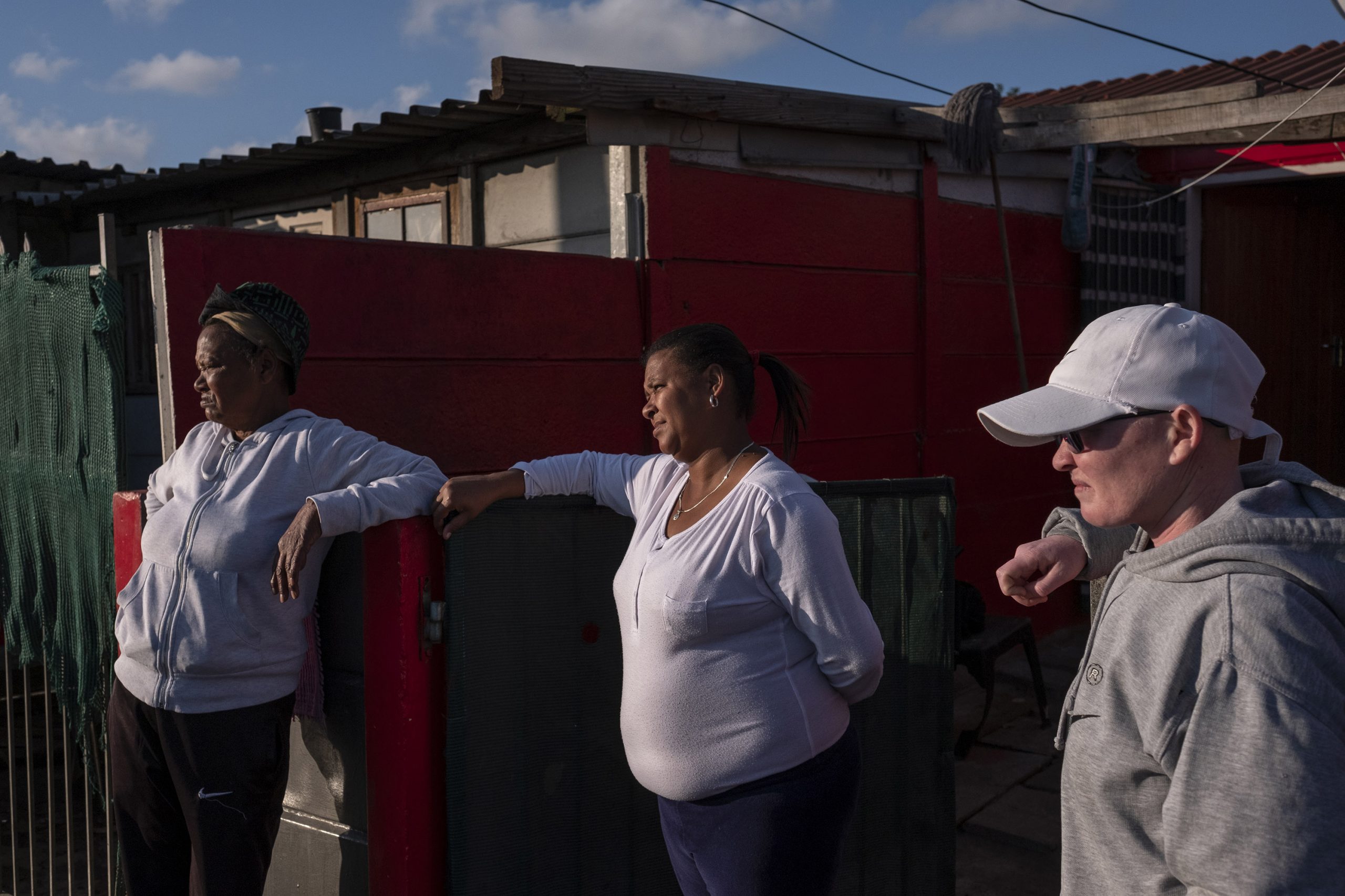 9 June 2020: From left, Cecilia Meintjies, Nora Southgate and Valene Meintjies stand in front of Cecilia Meintjies and Petrus Miggels’ house in Uitsig, where he used to stand and watch the world go by. 