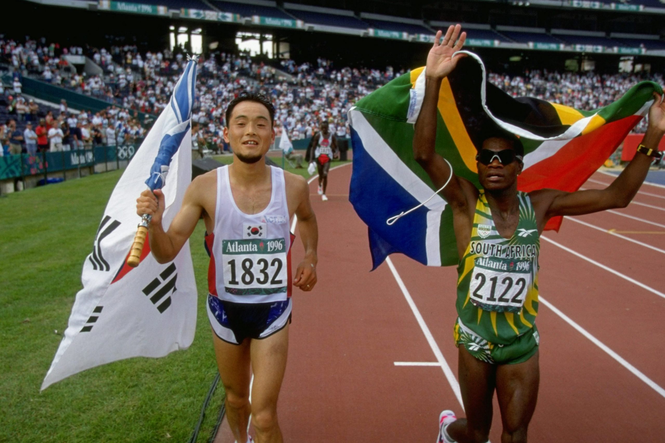 14 Aug 1996: Josia Thugwane celebrates with Bong-Ju Lee of South Korea after the men’s marathon at the Summer Olympics in Atlanta, Georgia. Thugwane won gold with Lee taking silver. (Photograph by Mike Powell/ Allsport)