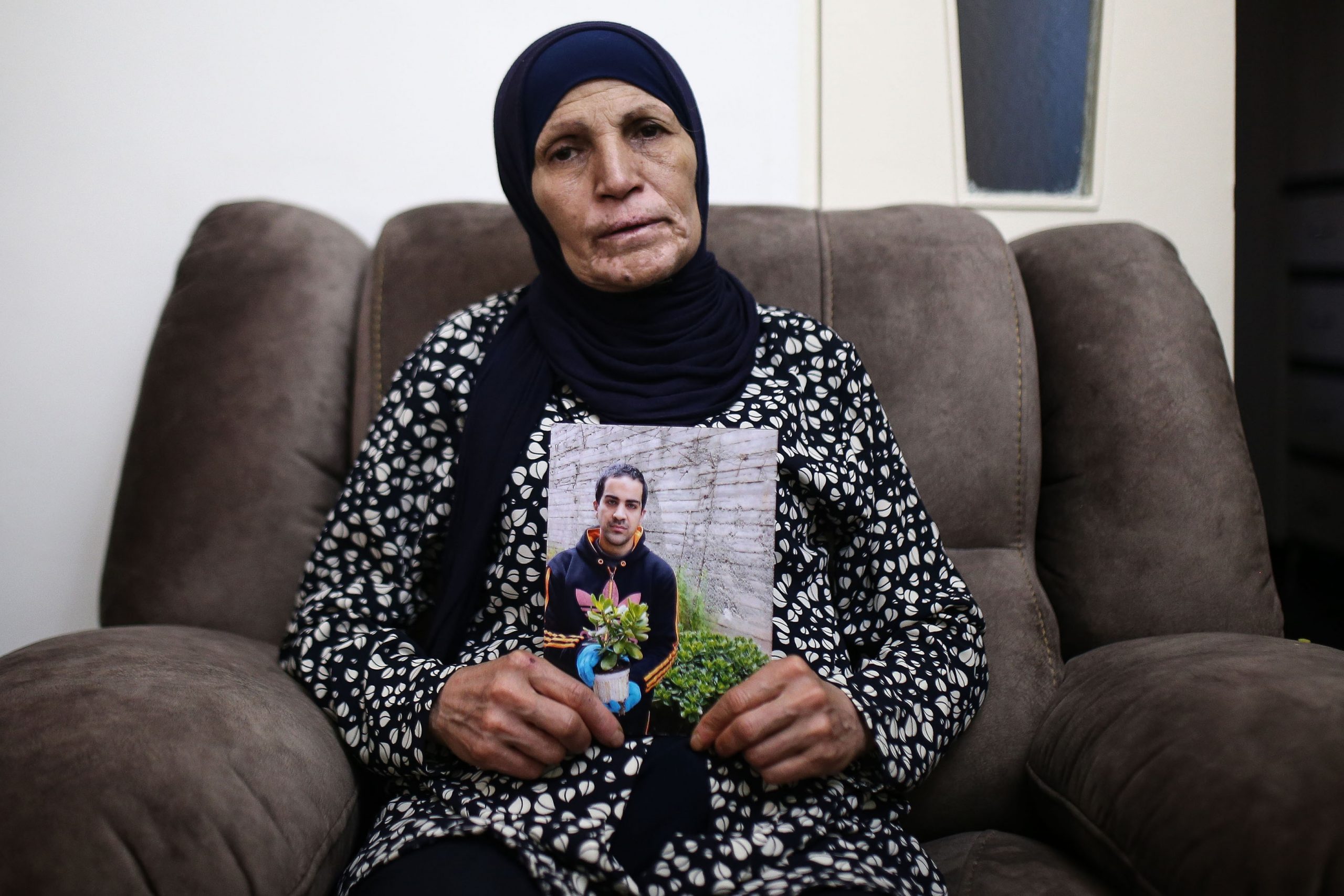 2 June 2020: Rana Hallak holds a photograph of her autistic son Iyad Hallak, 32, who was shot and killed by Israeli police in East Jerusalem's Old City on 30 May. (Photograph by Mostafa Alkharouf/ Anadolu Agency via Getty Images)