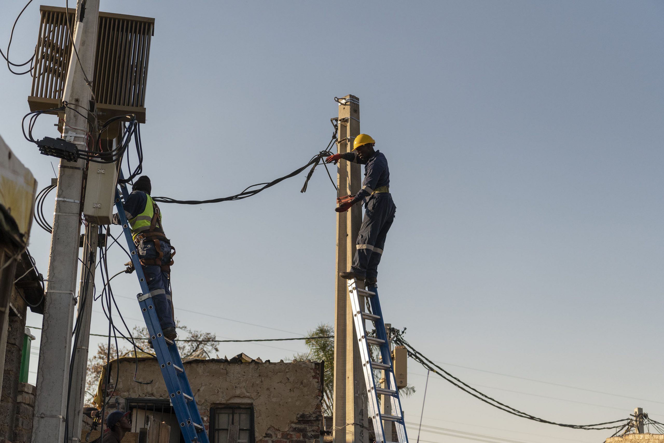 22 June 2020: City workers fix electricity pylons in the densely populated settlement of Stjwetla in Alexandra, Johannesburg. (Photograph by Ihsaan Haffejee)