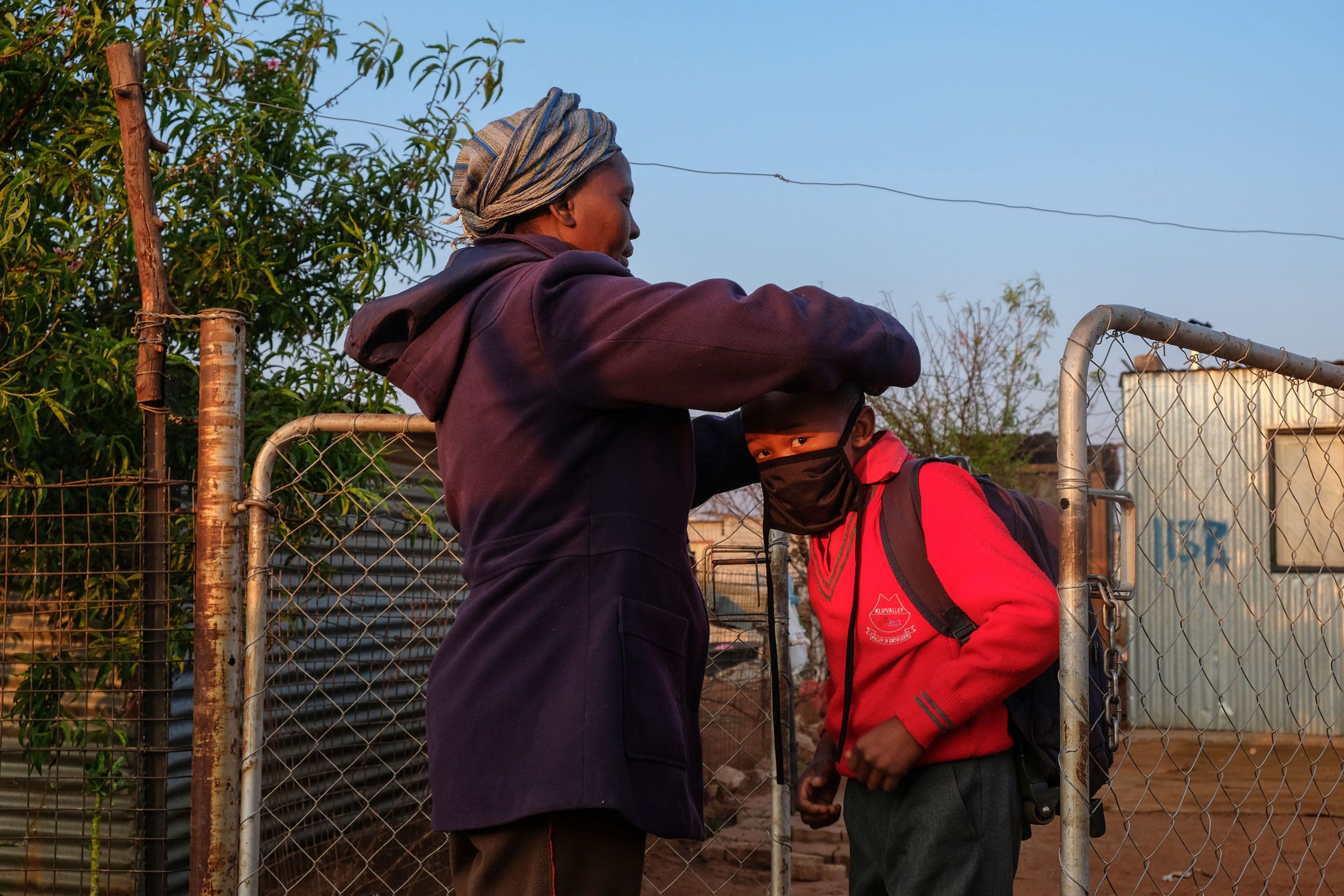 25 August 2020: Tamara Bhengu* takes a break from the protests to get her grandson ready for school. During the Covid-19 lockdown, children’s homework was sent on WhatsApp, but without electricity Doornkop residents could not charge their cellphones. 