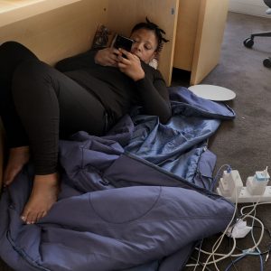 15 March 2021: Opera singer Sibongile Mngoma rests under the table in the National Arts Council’s boardroom. She is one of the artists staging a sit-in to force the government to pay out funds promised to artists. (Photograph by John Hogg)